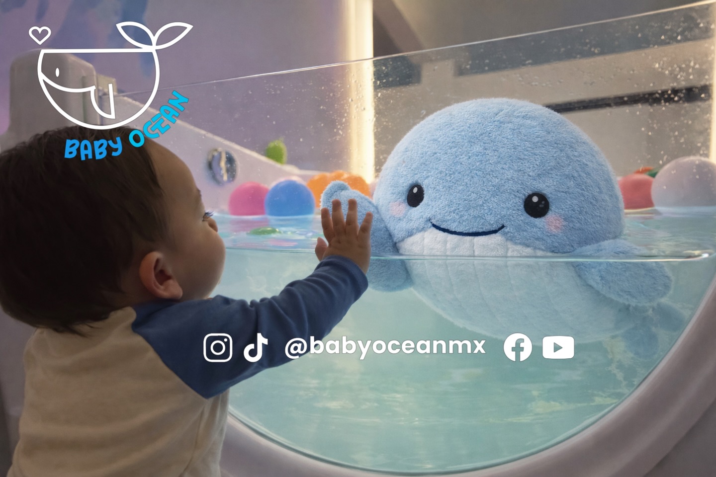 Bebé interactuando con peluche ballena en la tina